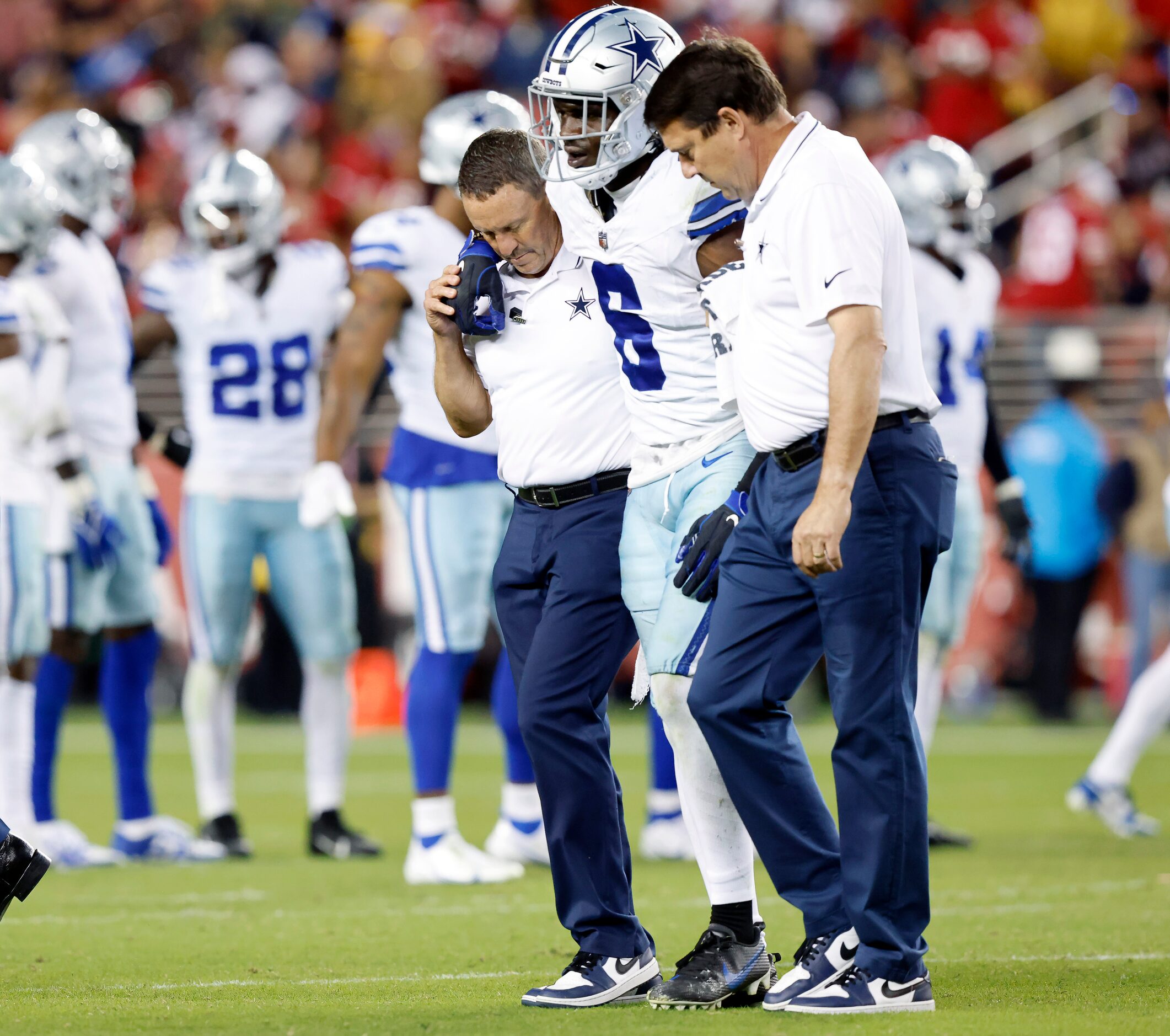 Dallas Cowboys safety Donovan Wilson (6) is helped off the field by trainers after...