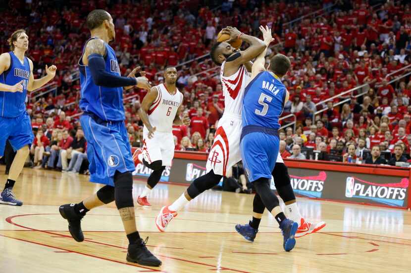 Houston Rockets guard James Harden (13) drives through Dallas Mavericks guard J.J. Barea (5)...