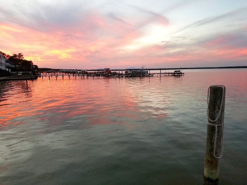 A sunset cruise aboard a catamaran in Wolf Bay off the Alabama Coast shows off the painted...