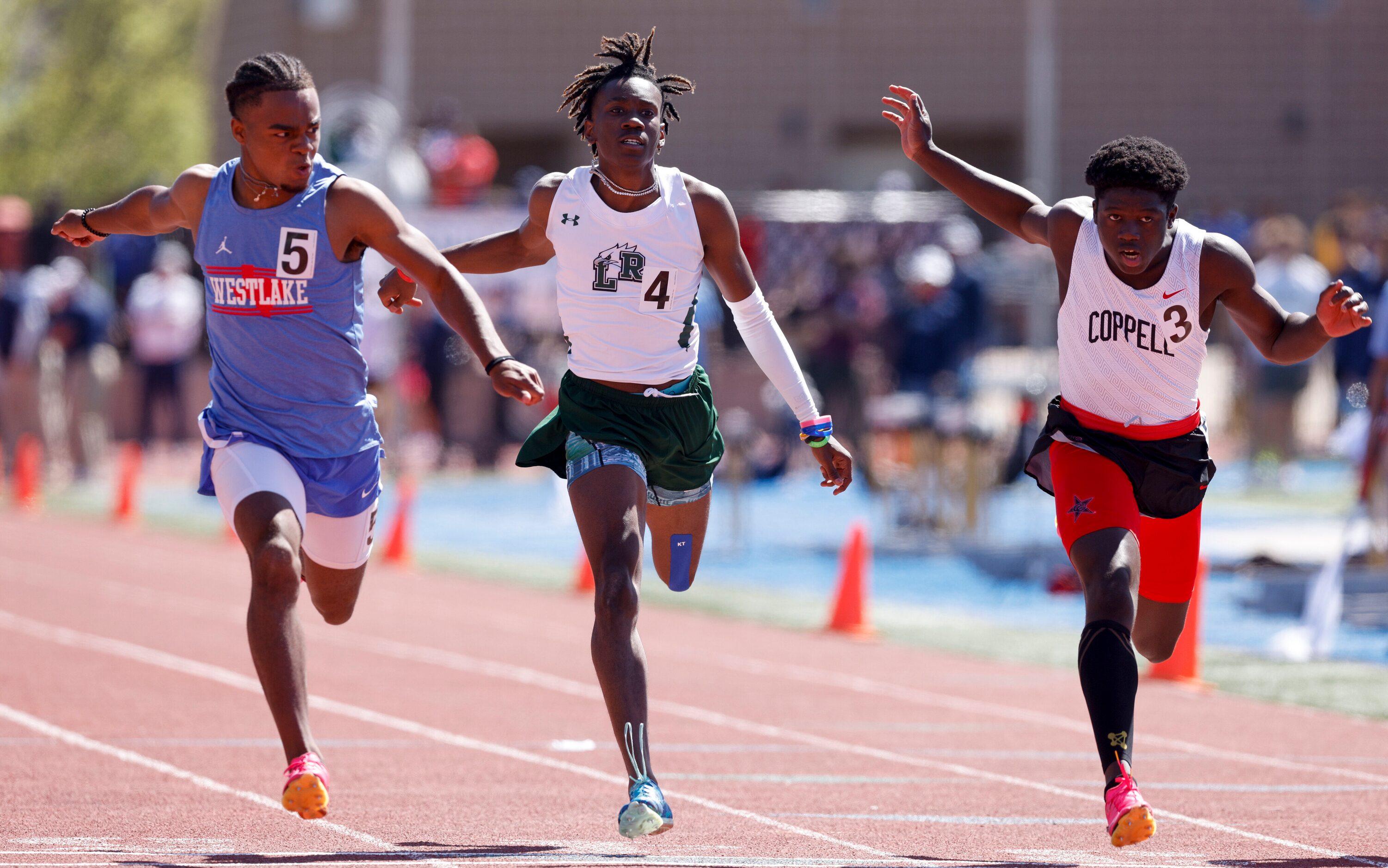 Austin Westlake’s Ashton Torns (left) wins the 6A 100 meter dash ahead of Mansfield Lake...