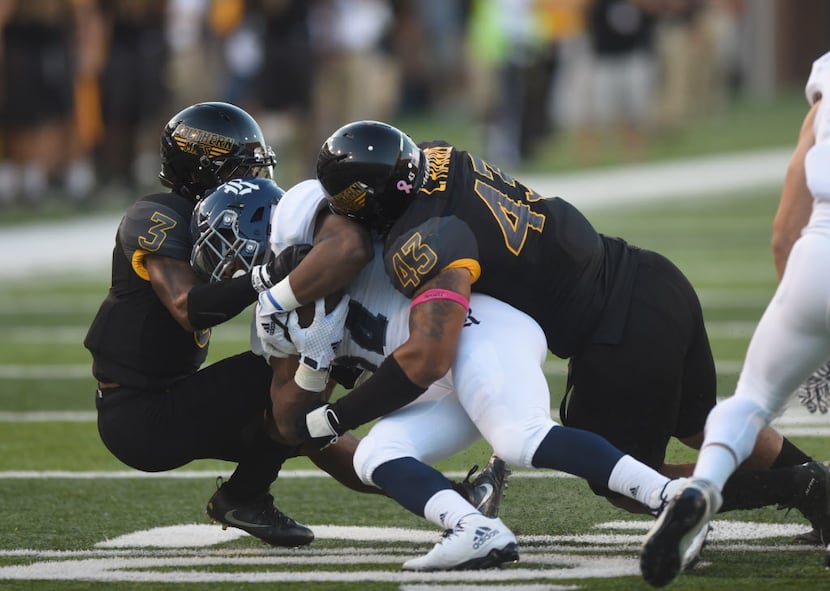 Southern Mississippi's Cornell Armstrong, left, and LaDariusHarris make a tackle against a...
