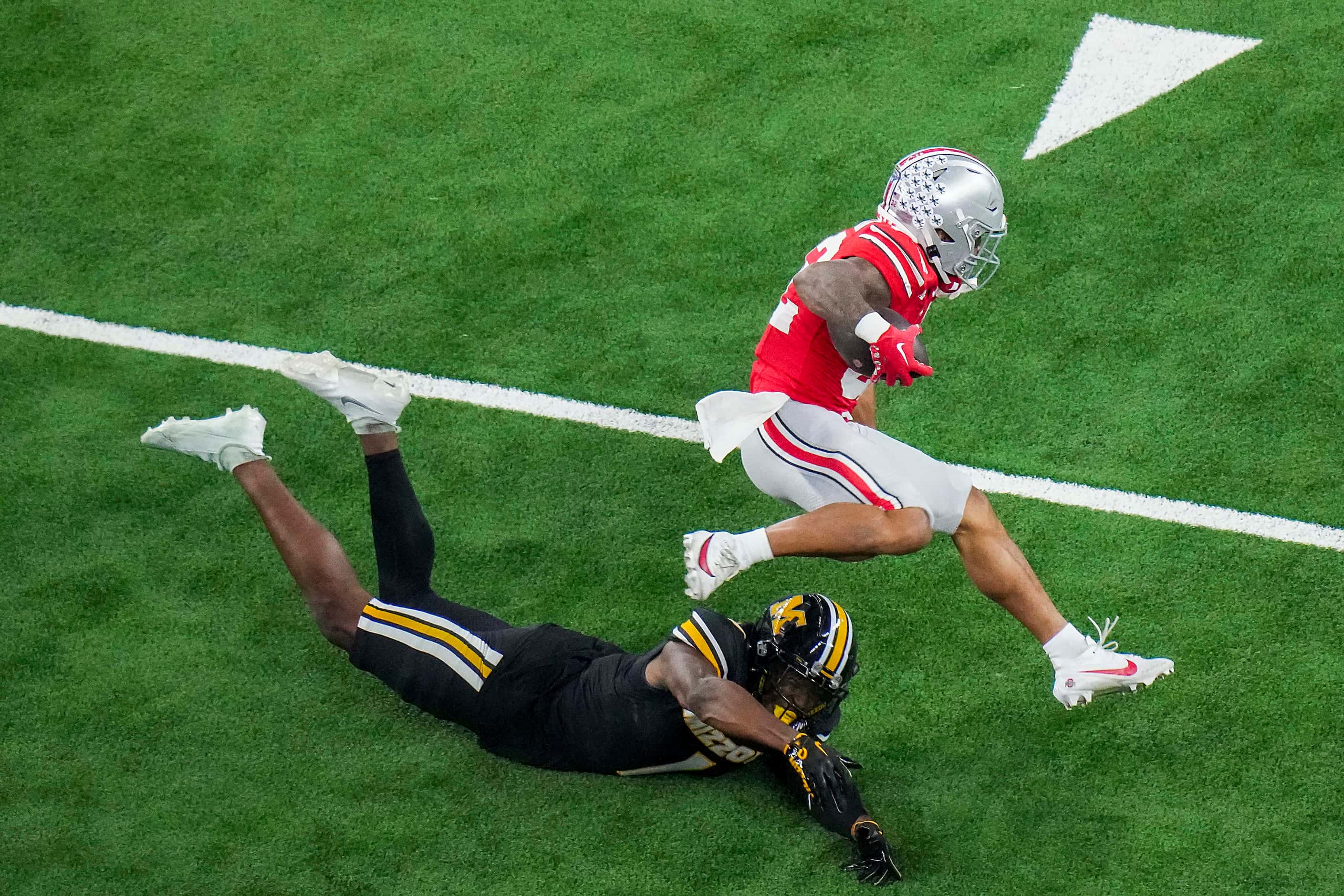 Ohio State running back TreVeyon Henderson (32) tries to leap over Missouri defensive back...
