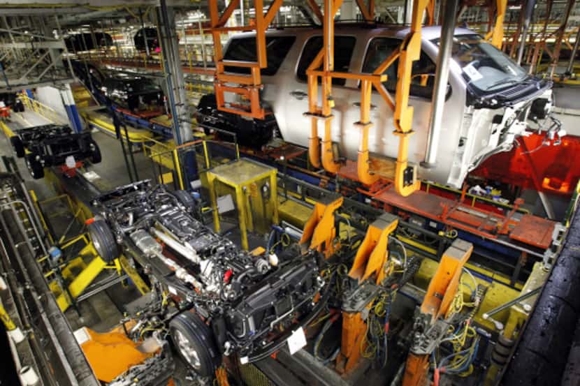 An SUV body is positioned seconds before being lowered onto a chassis at the GM Assembly...