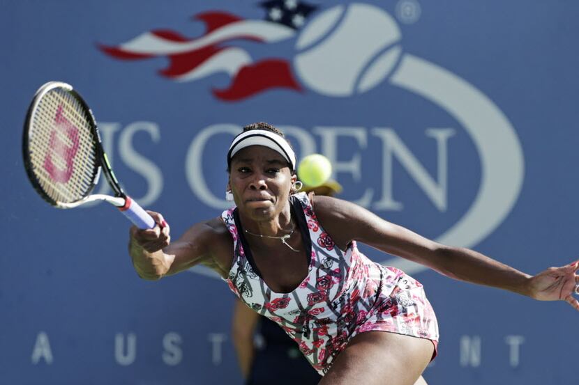 Venus Williams returns a shot to Bethanie Mattek-Sands during the first round of play at the...