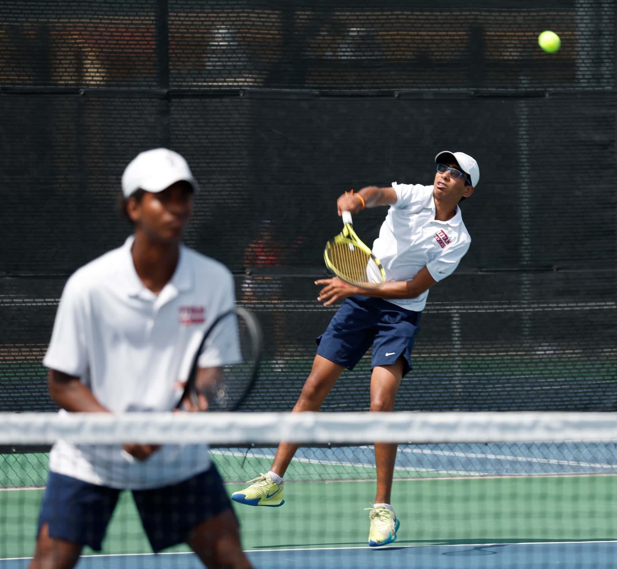 5A boys doubles final: Frisco Centennial's  Akshay Kommineni serves as teammate Eduardo Cruz...