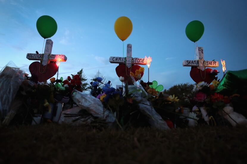 Crosses line the lawn in front of Santa Fe High School on Monday, May 21, in Santa Fe. The...