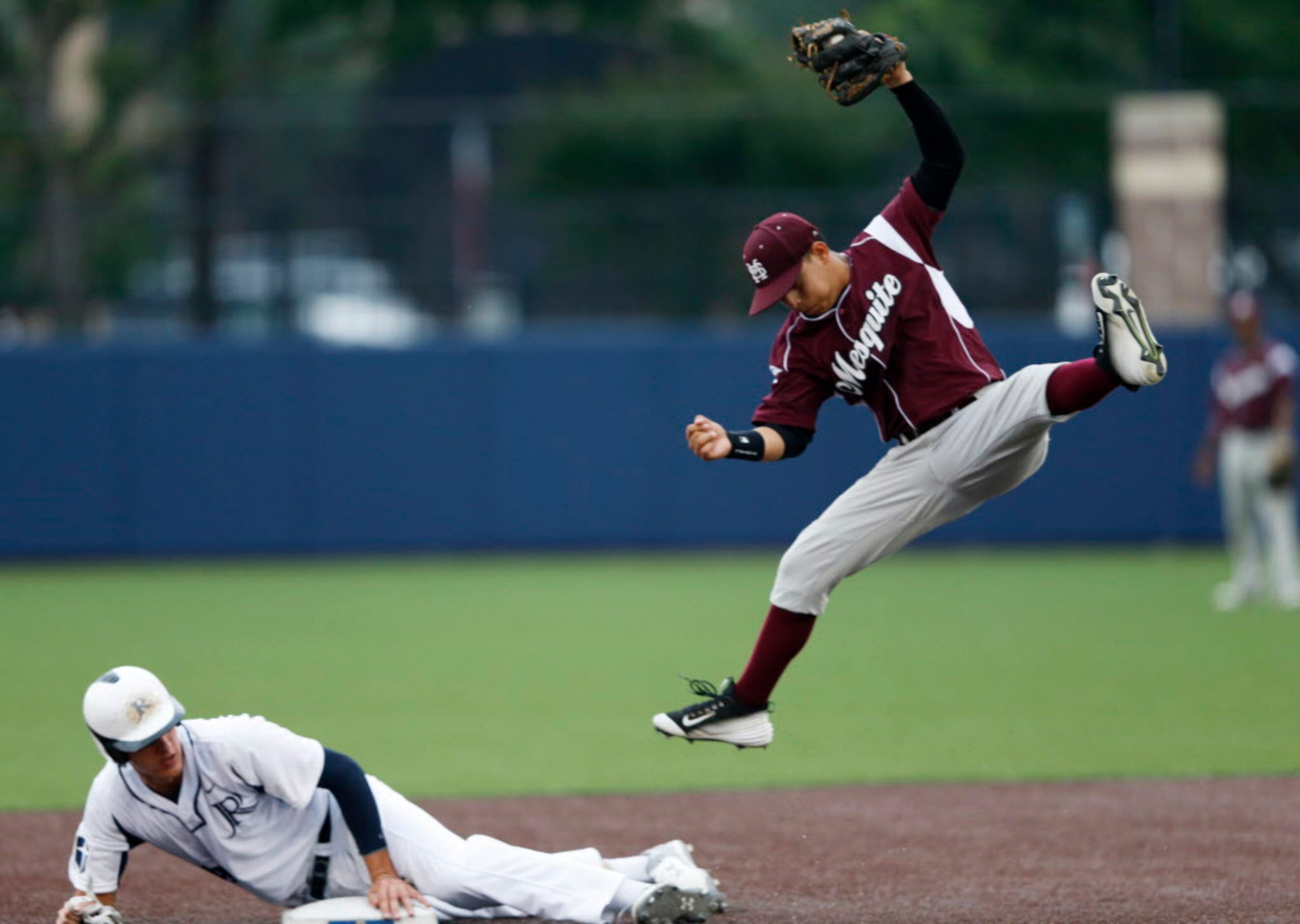 Jesuit's Kyle Muller (19) safely slides into second base as Mesquite's Johnny Rojo (16)...