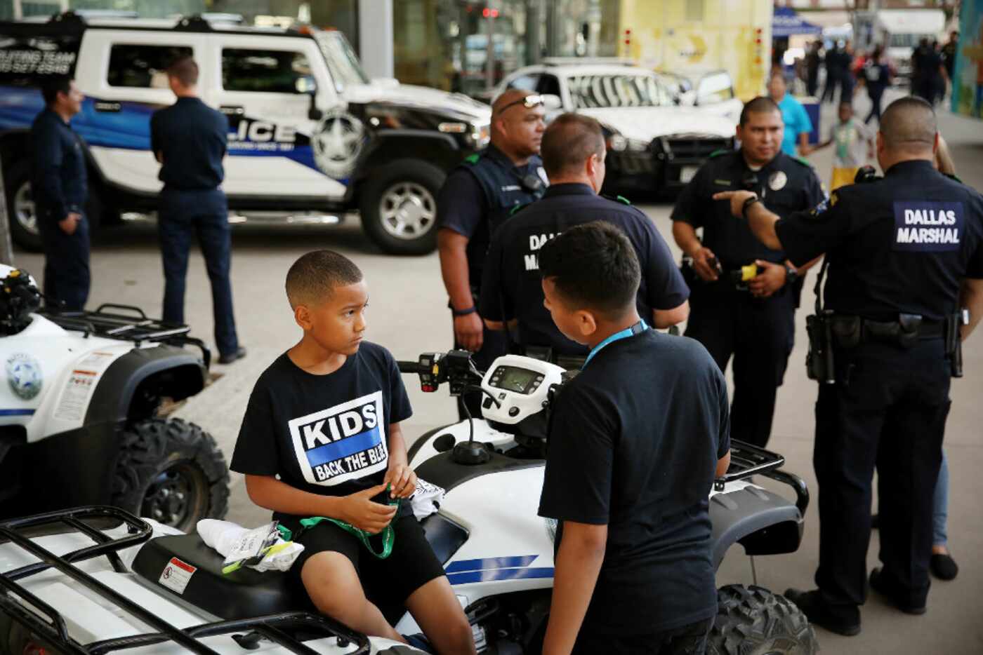 Rodney Gilcreast (left), 12, and Davion Page check out a utility vehicle while the Dallas...