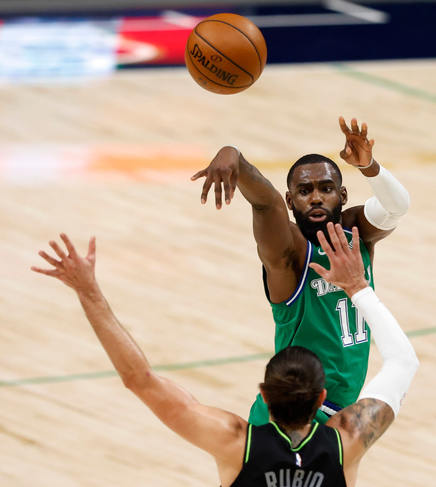 Dallas Mavericks guard Tim Hardaway Jr. (11) passes over Minnesota Timberwolves guard Ricky...