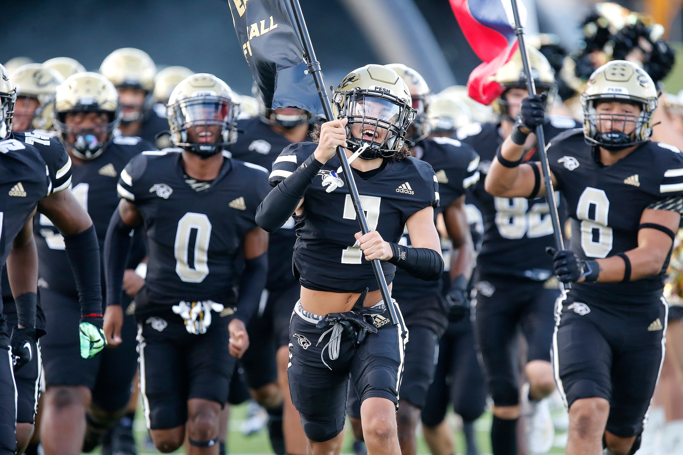 Plano East Senior High School defensive back Christopher Mcgowan (7) leads his team onto the...