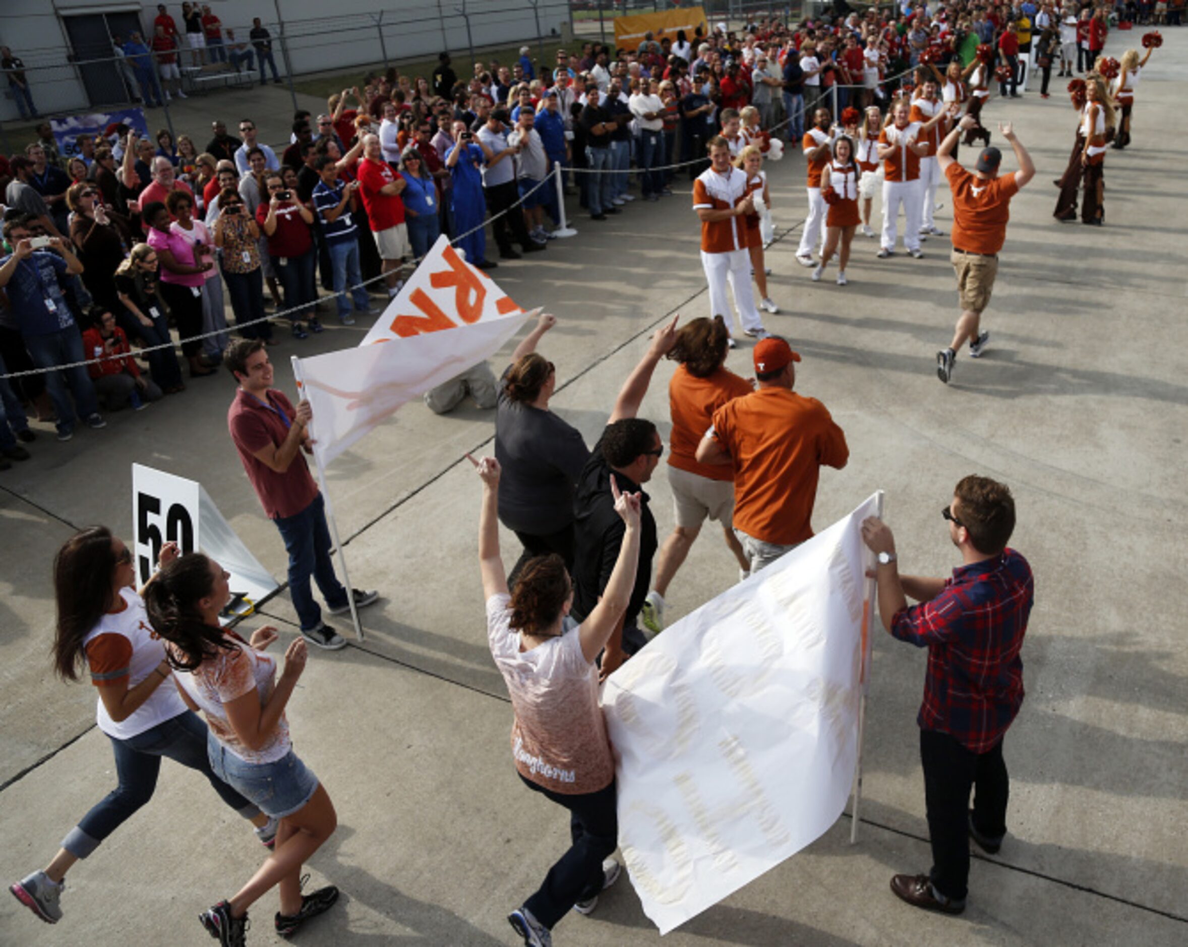 Southwest Airlines employees representing the University of Texas run through the team...