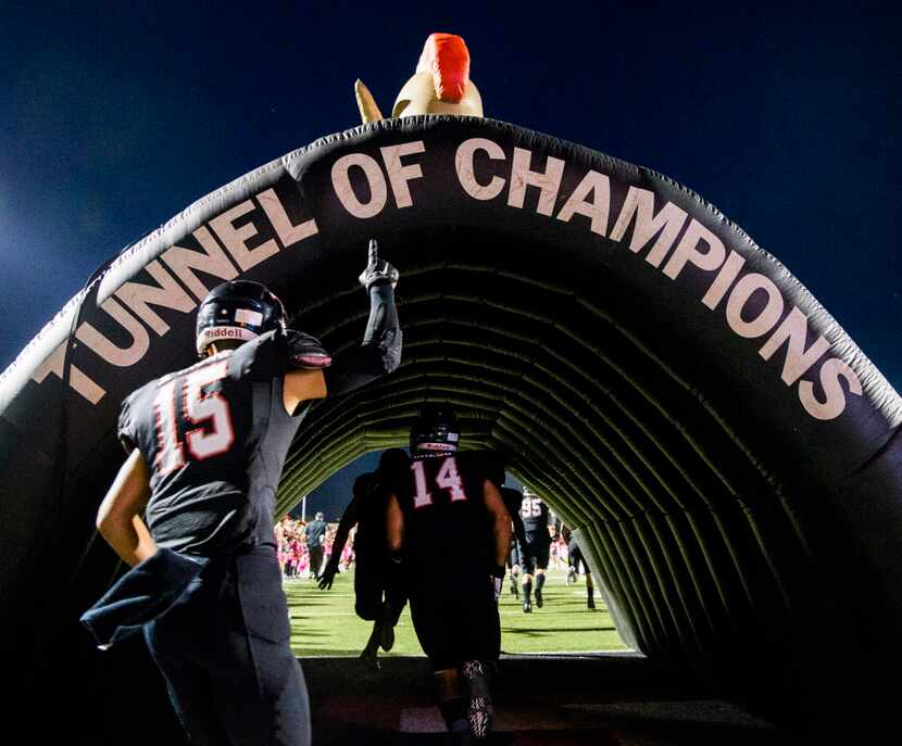 Euless Trinity defensive back Sampson Tasini (15) and linebacker Justus Gregg (14) run...