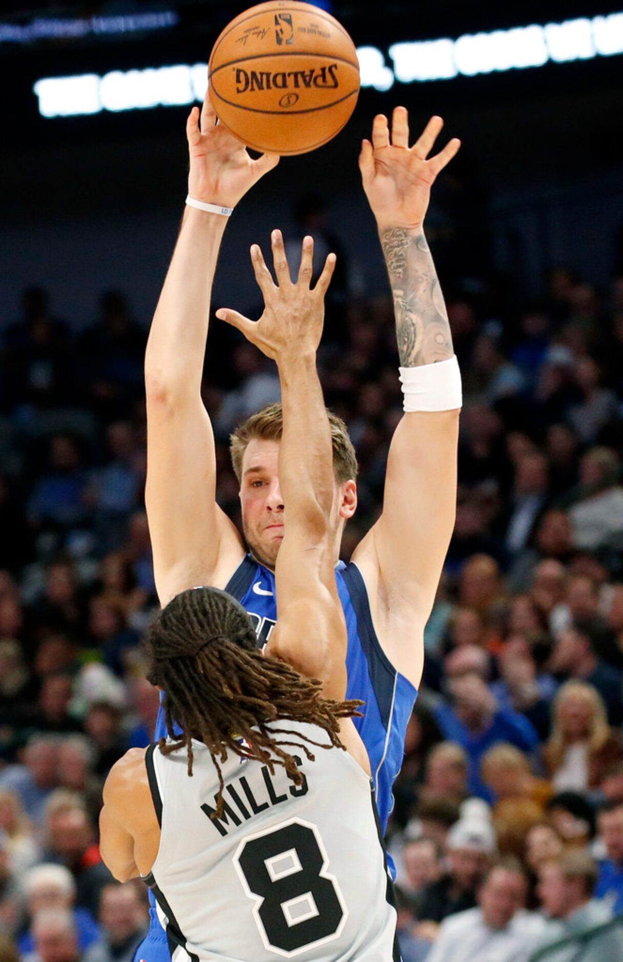 Dallas Mavericks forward Luka Doncic (77) passes the ball over San Antonio Spurs guard Patty...