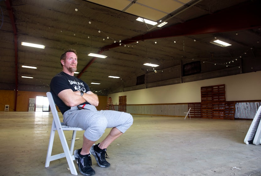 The Party Venue owner Heath Jackson sits in the open garage doorway of business outside...