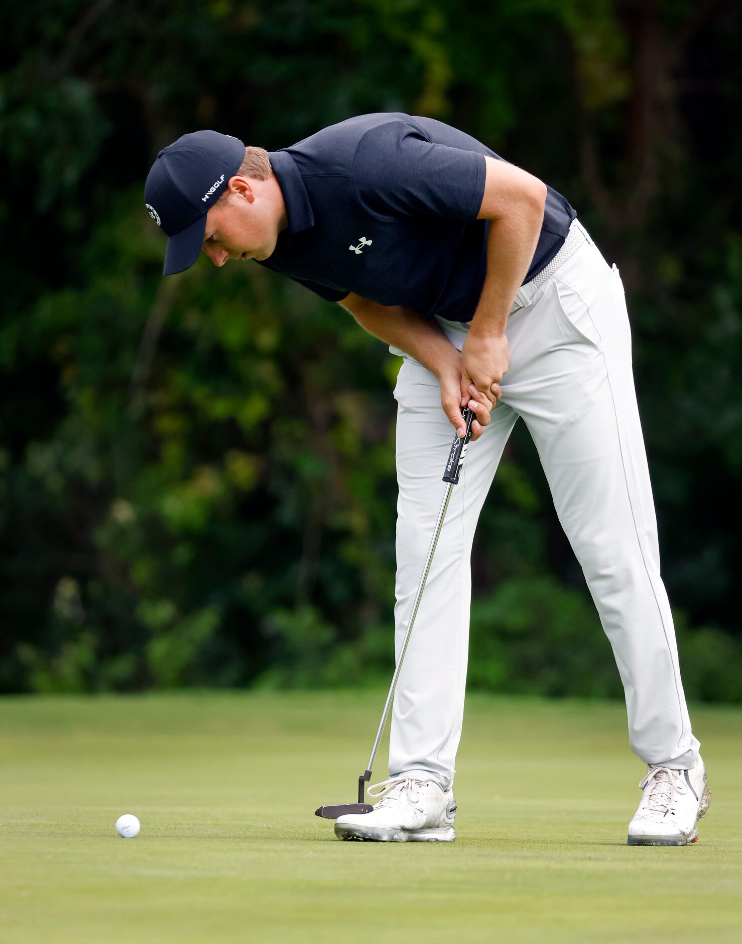 Professional golfer Jordan Spieth stares at his ball on the lip of the No. 7 hole, hoping it...