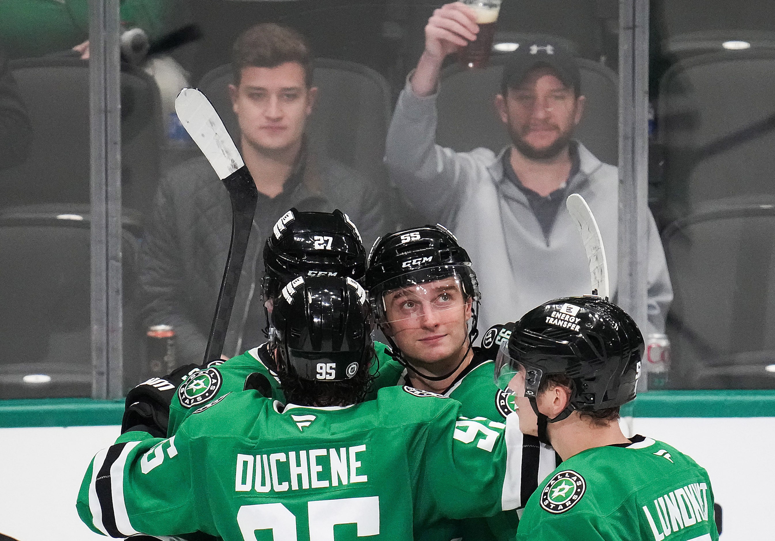 Dallas Stars defenseman Thomas Harley (55) celebrates with teammate as a fan raises a beer...