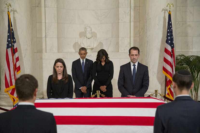  President Barack Obama and first lady Michelle Obama pauses as they pay respects beside the...