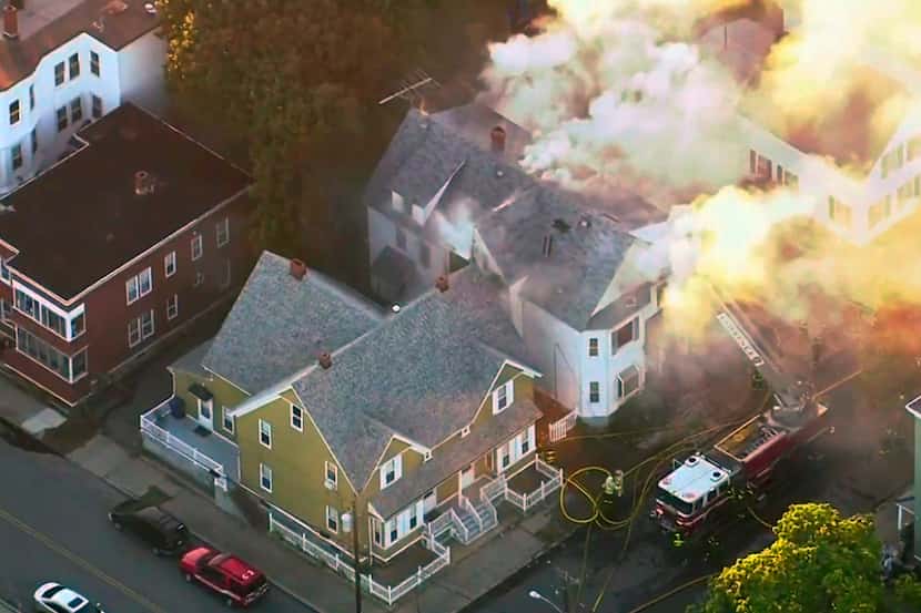 In this image take from video provided by WCVB in Boston, firefighters battle a large...