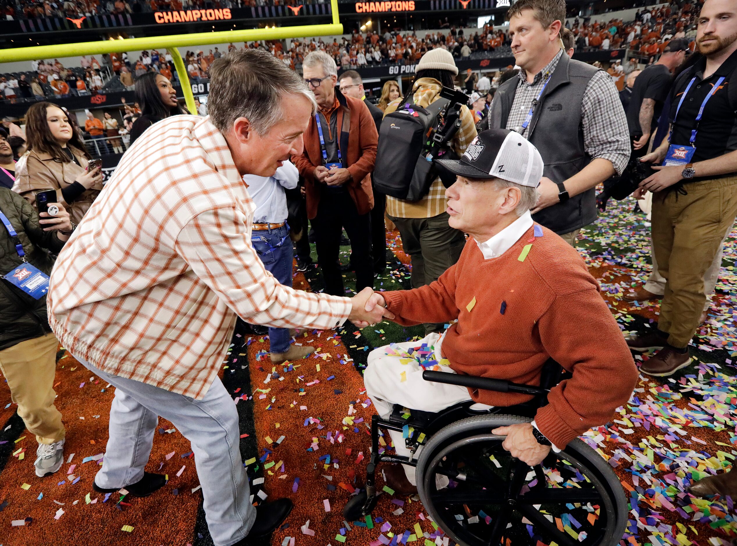 Texas Governor Greg Abbott (right) congratulates University of Texas President Jay Hartzell...