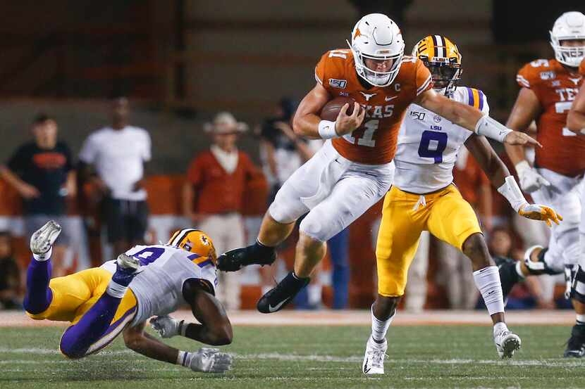 Texas Longhorns quarterback Sam Ehlinger (11) goes airborne in an attempt to evade LSU...