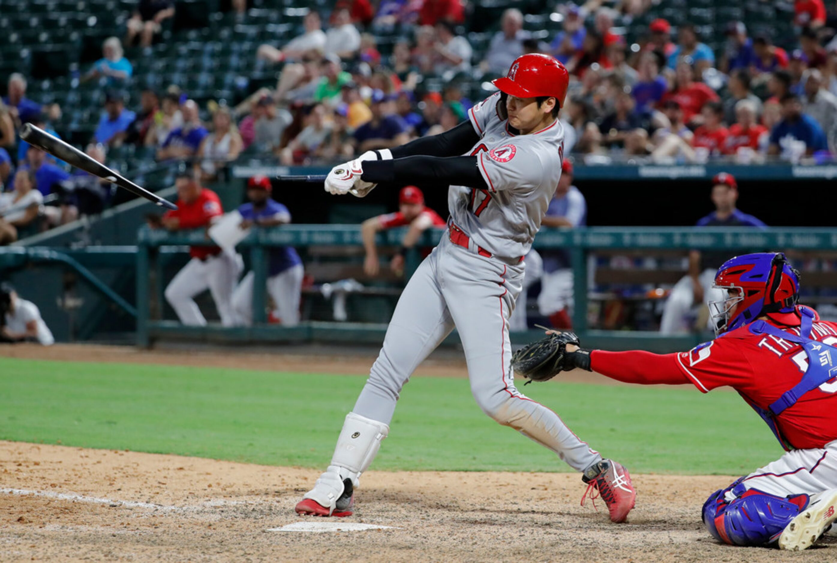 Los Angeles Angels' Shohei Ohtani breaks his bat hitting into a double play as Texas...