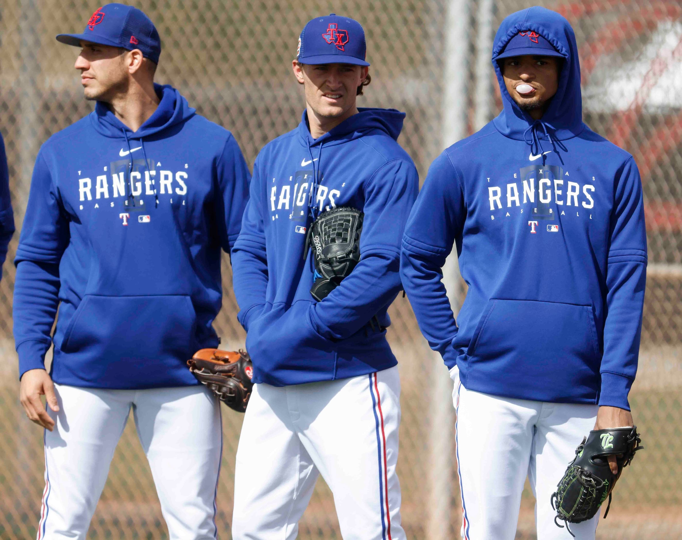 Texas Rangers pitcher Jacob Barnes, left, Jake Latz, center, and Marc Church wait for a...