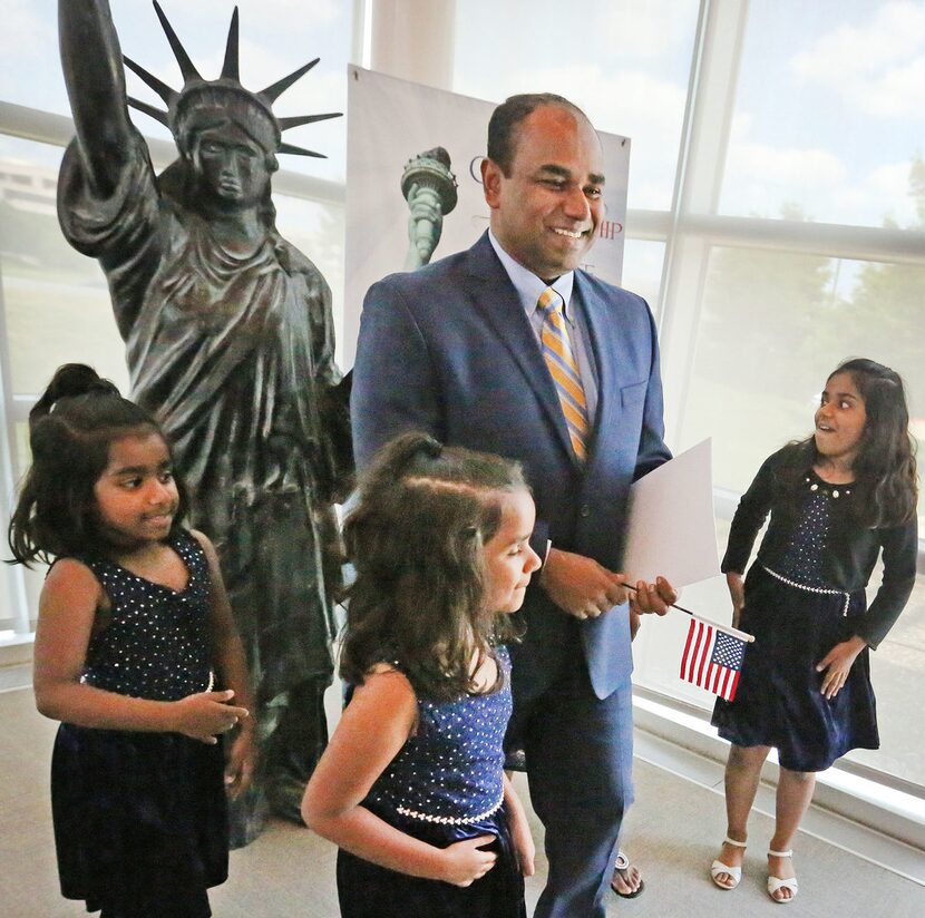 Manoj Mathew from India, center, is all smiles as he celebrates his American citizenship...