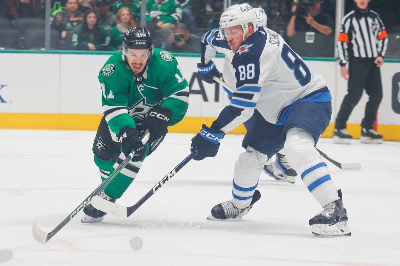 Dallas Stars center Logan Stankoven (left) controls the puck against Winnipeg Jets...