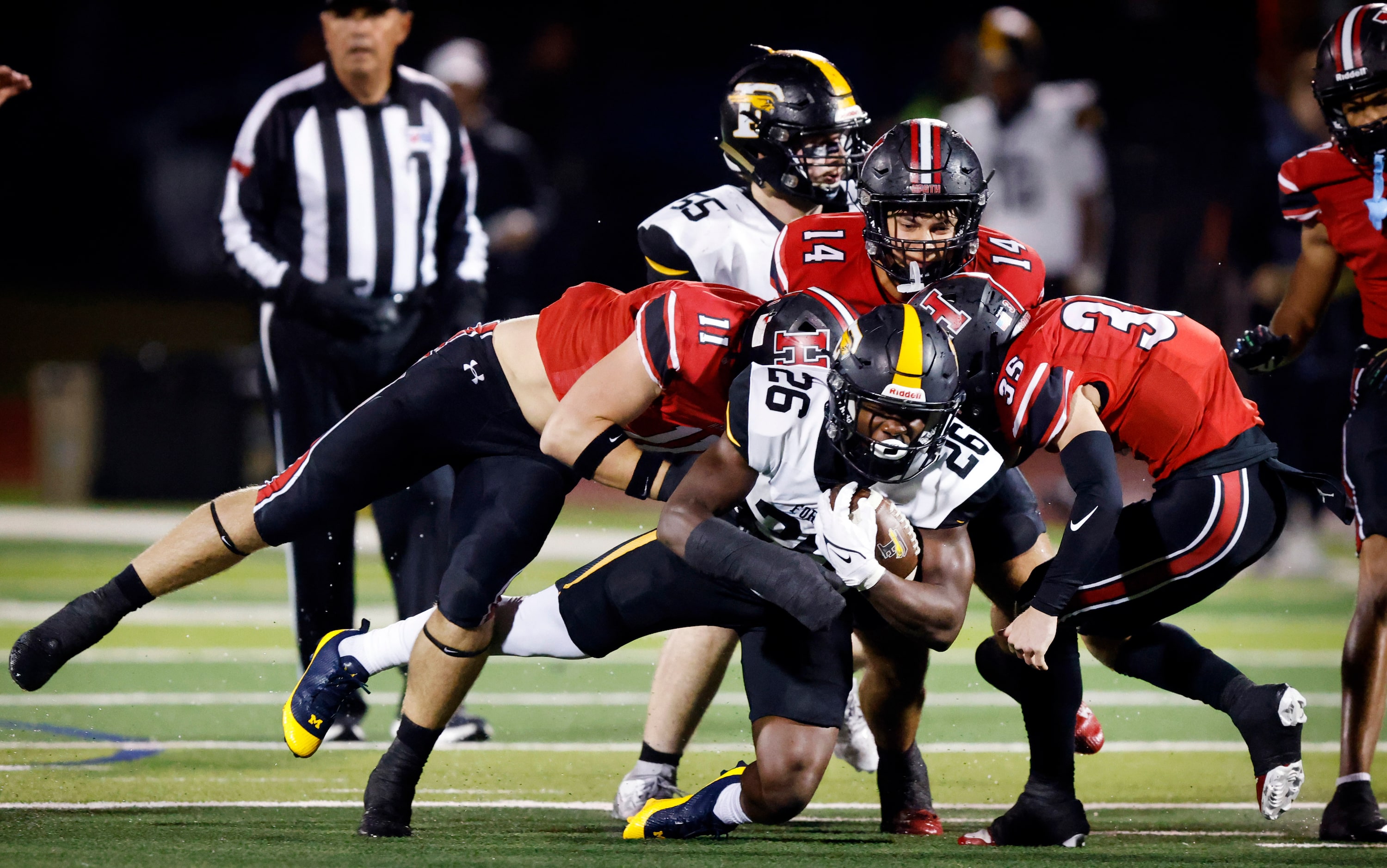 Forney running back Javian Osborne (26) is tackled by Rockwall-Heath’s Layne Yudizky (11)...