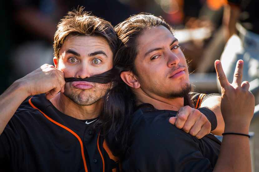 San Francisco Giants shortstop Chase d'Arnaud makes a mustache out of the hair of pitcher...
