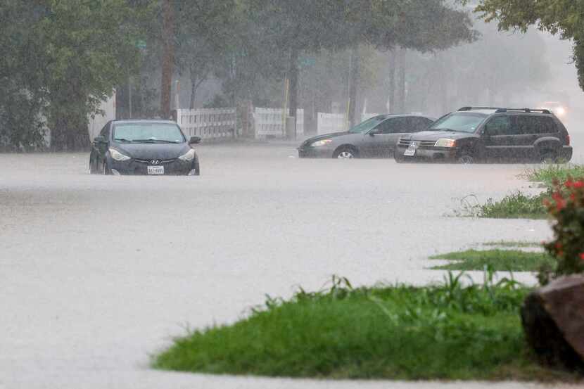 Cars sat stranded along a flooded Lawnview Avenue near Interstate 30 in Dallas on Aug. 22,...