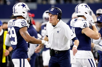 Dallas Cowboys special teams coach John Fassel congratulates cornerback C.J. Goodwin (29)...