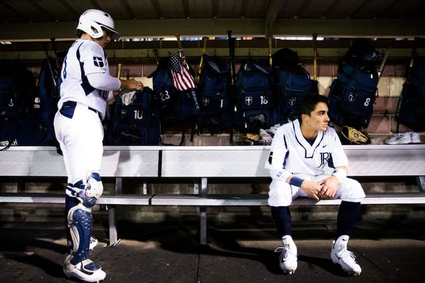 Jesuit's Michael Schoettmer (10) puts on his gloves as John Guzman (1) sits in the dugout...
