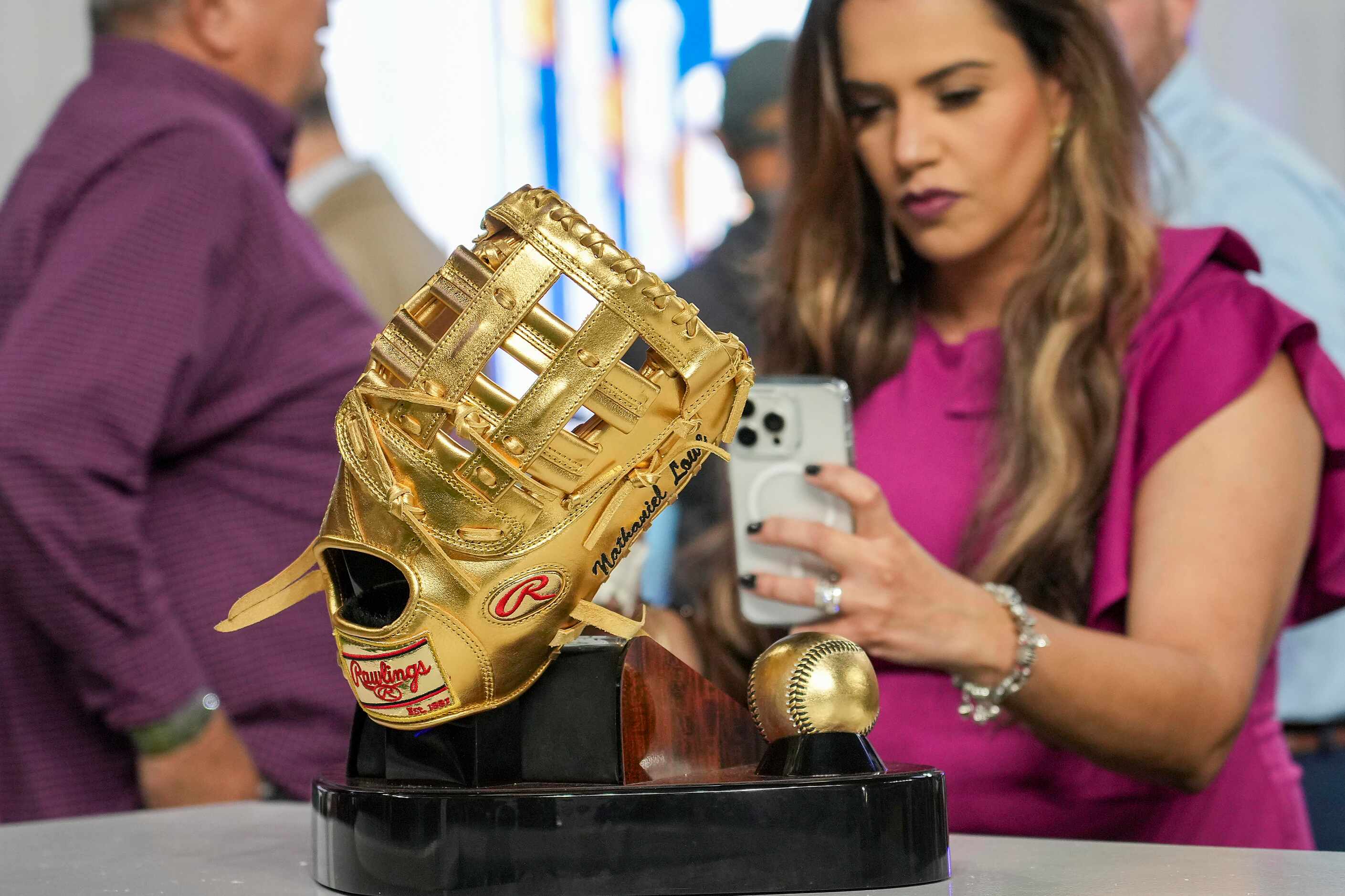 A guest takes a photo of Texas Rangers first baseman Nathaniel Lowe’s 2023 Gold Glove on...