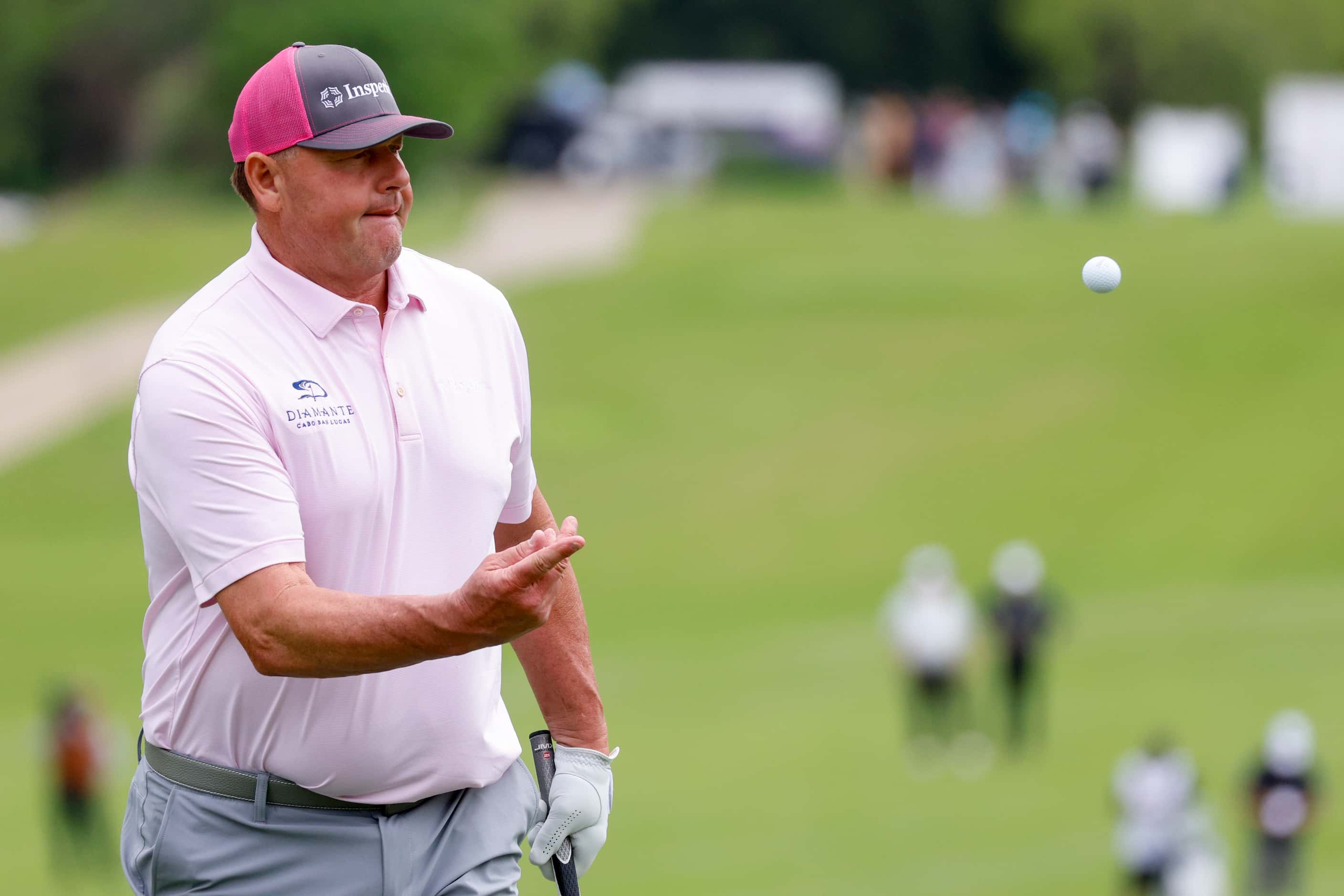 Former MLB pitcher Roger Clemens tosses his ball to his caddie after the first round of the...