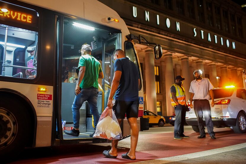 A group of people board a Chicago Transit Authority bus before being taken to a Salvation...