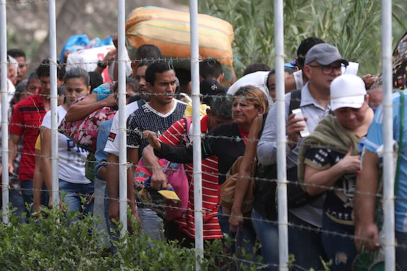 Un grupo de venezolanos deja su país al cruzar la frontera con Colombia, en espera de ayuda...