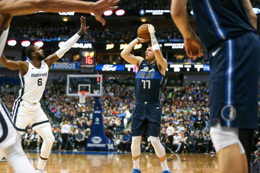 Dallas Mavericks forward Luka Doncic (77) shoots over Memphis Grizzlies forward CJ Miles (6)...