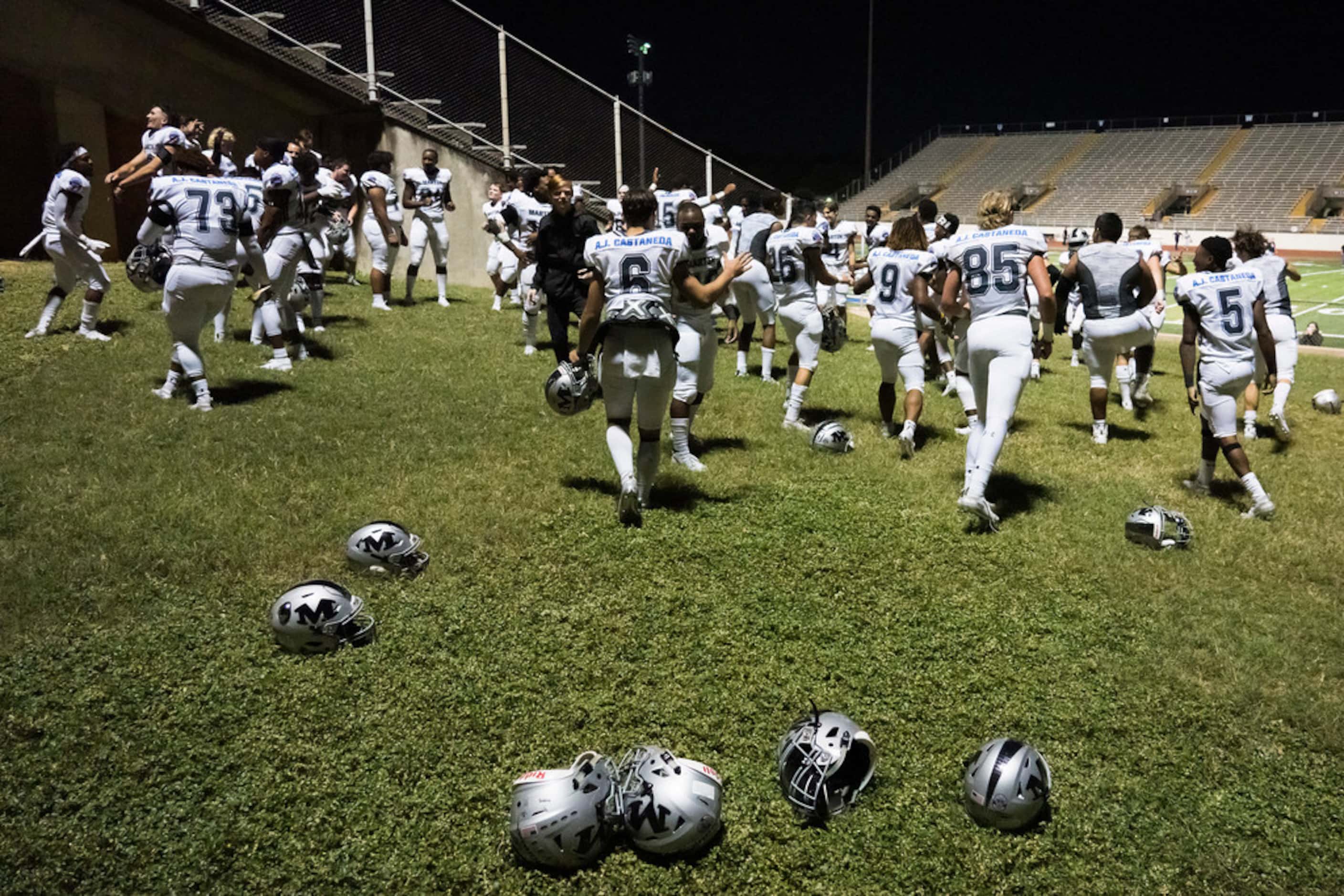 Arlington Martin players dance to the song outside the locker room as they celebrate a...