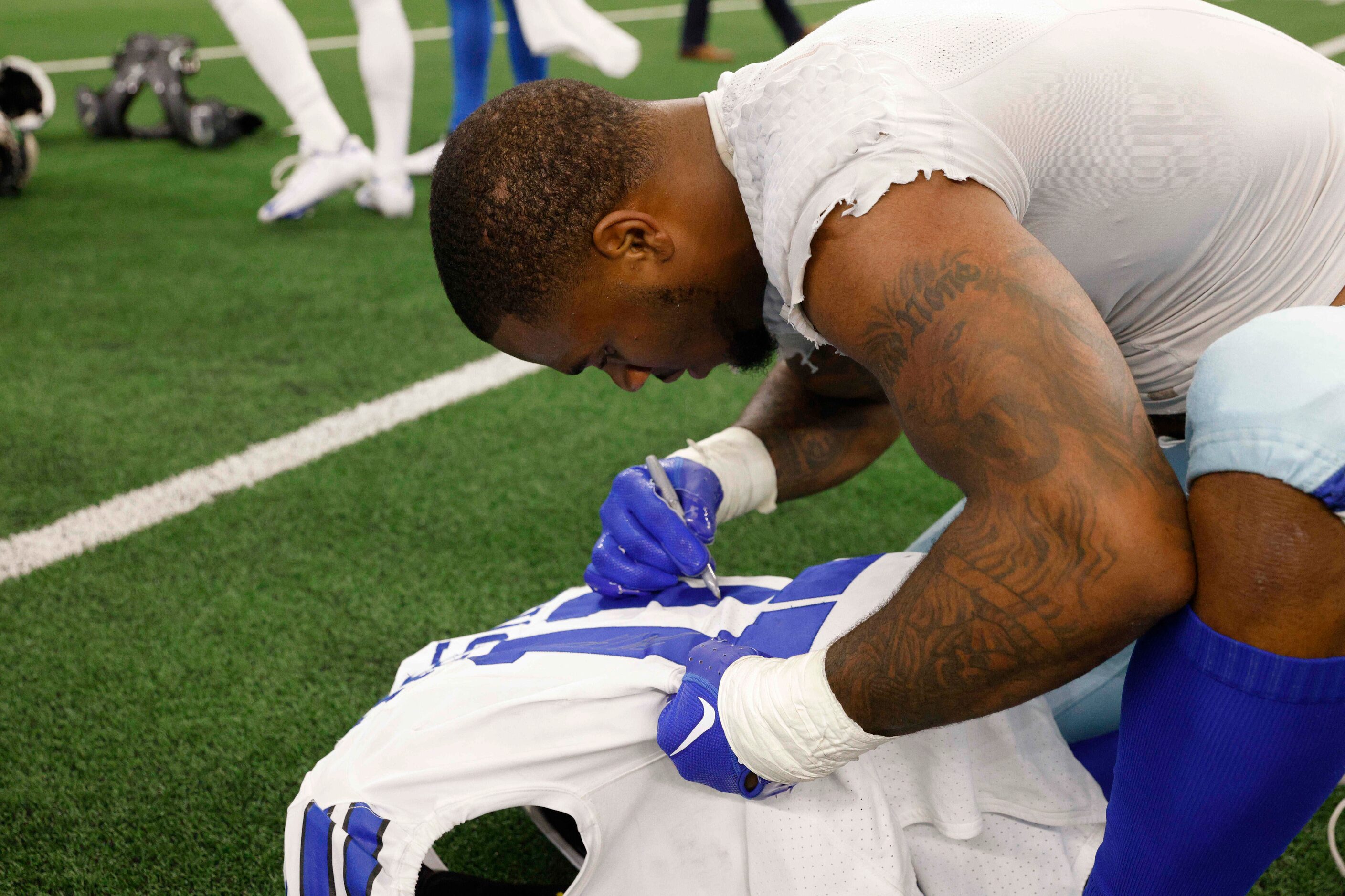 Dallas Cowboys linebacker Micah Parsons (11) autographs his jersey after a NFL game against...