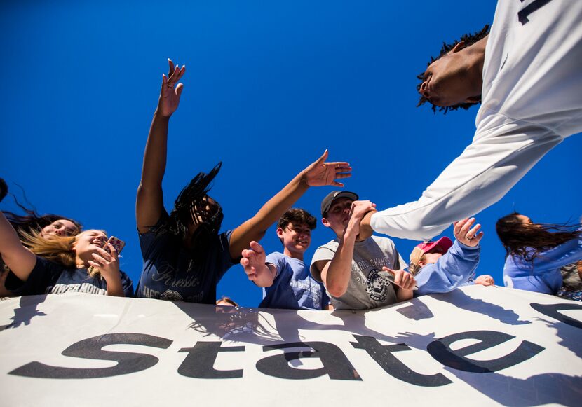 Flower Mound forward Jereme Gordon (11) high-fives fans after a 3-2 win in a UIL conference...