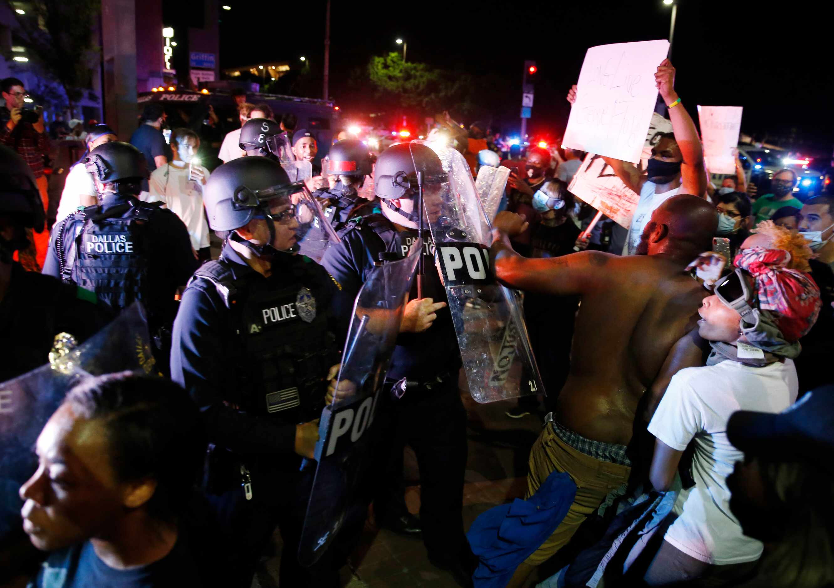 Dallas police interact with  protesters during a rally against police brutality in downtown...