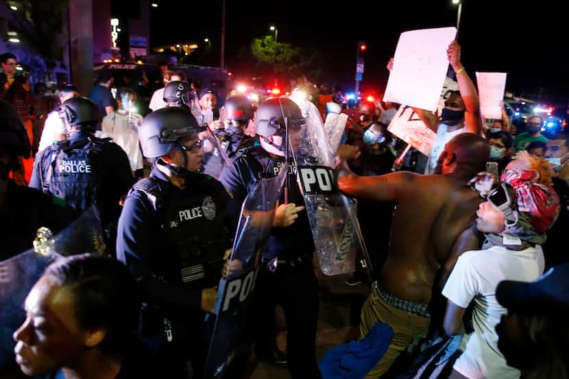 Policías interactúan con manifestantes durante las protestas de Black Lives Matters de mayo...