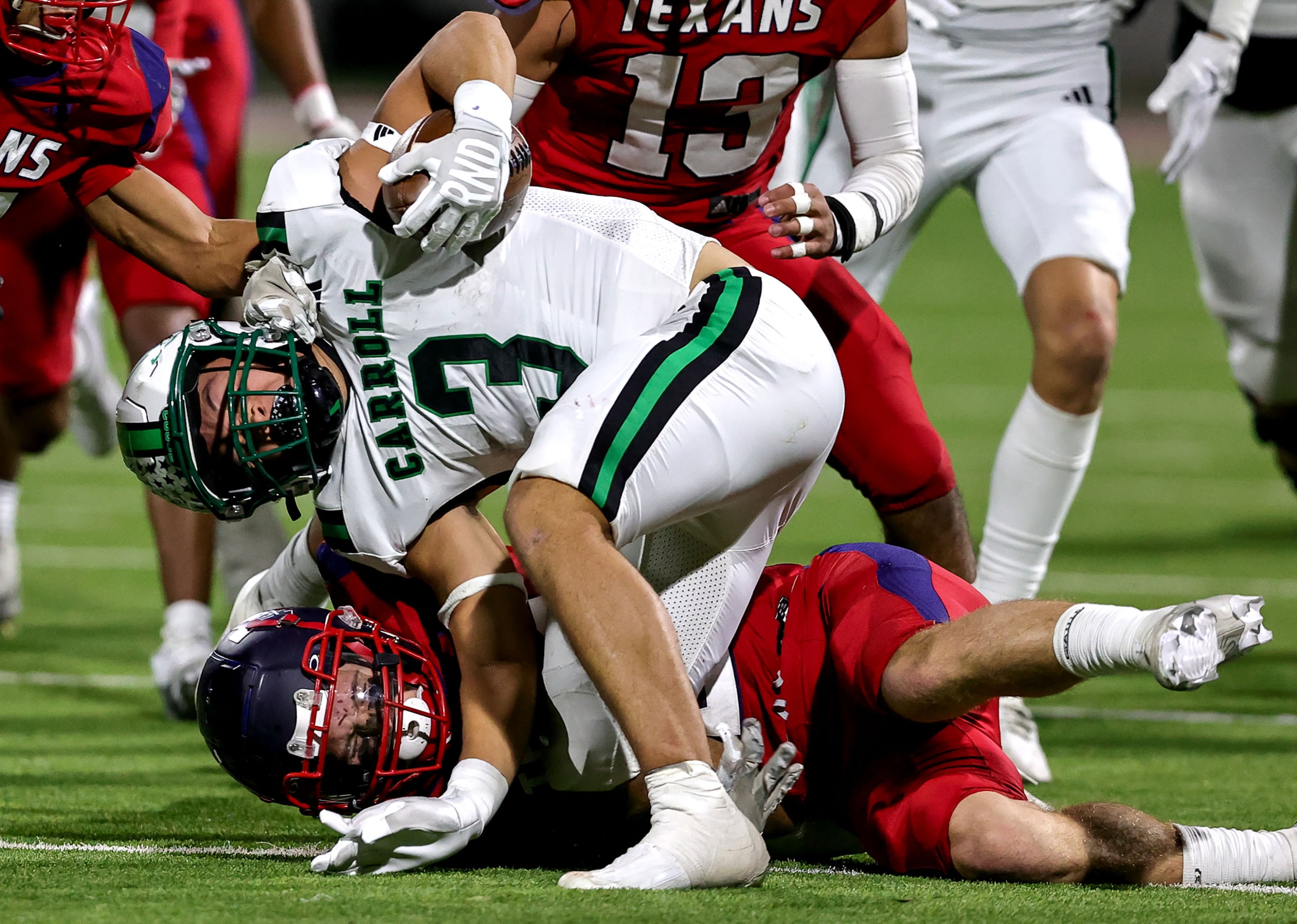 Southlake Carroll running back Davis Penn (3) gets dragged down by Justin Northwest...