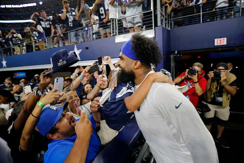 A young fan receives a hug and an autograph from Dallas Cowboys running back Ezekiel Elliott...