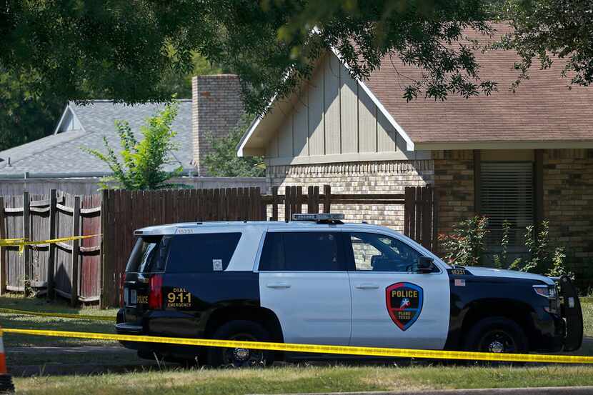 A Plano police officer secures a home on West Spring Creek Parkway where Spencer James Hight...