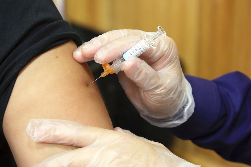 FILE - In this Friday, Sept. 22, 2017 file photo, a flu vaccine injection is administered at...