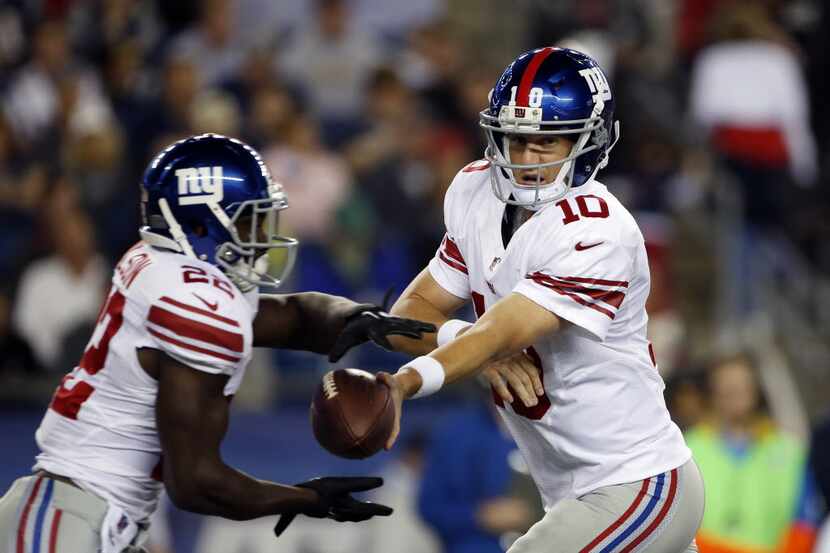 New York Giants quarterback Eli Manning (10) hands off to running back David Wilson (22)...