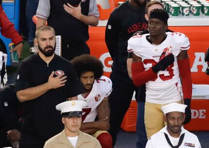 San Francisco 49ers quarterback Colin Kaepernick (7) kneels during the national anthem...