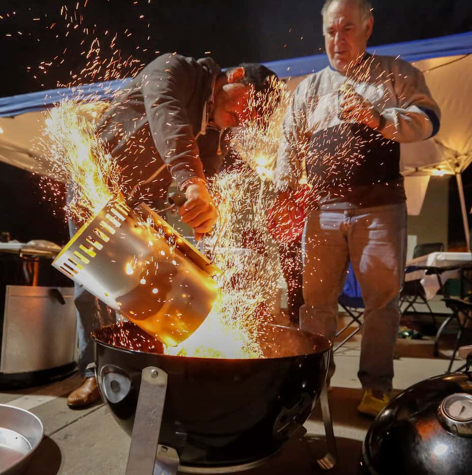 Jacob Sullum and Donny Swartz pour heated coals into the team's smoker at the  Dallas Kosher...